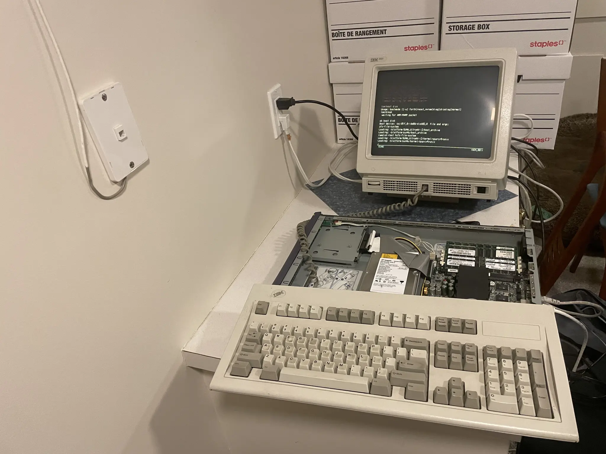 terminal keyboard on top of open chassis of server, screen of terminal behind