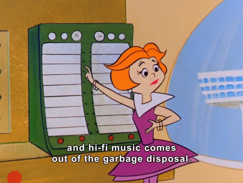 In this animated scene, a female character with bright orange hair is depicted in a retro-futuristic kitchen. She wears a striking purple dress with a wide collar, exuding a cheerful and animated demeanor. Her hand gestures express enthusiasm as she interacts with a large, multi-panel control console behind her, which appears to be designed for managing household functions. 

The console features several buttons and indicators, hinting at advanced technology for the time. A round window beside her reveals a sleek, futuristic cityscape, suggesting an innovative environment. The scene captures a playful blend of domesticity and technology, emblematic of the futuristic themes found in classic animation. 

Subtitled text across the image adds a humorous touch, stating, "and hi-fi music comes out of the garbage disposal," further enhancing the whimsical atmosphere.