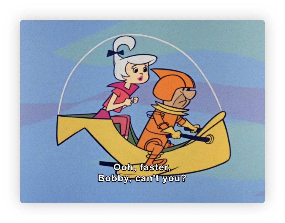 This image features two animated characters from a classic cartoon, seated in a futuristic yellow vehicle. The female character, dressed in a pink outfit and white helmet, is urging the male character, who is wearing an orange suit and helmet, to increase their speed as indicated by her dialogue in the caption: "Ooh, faster, Bobby, can't you?" The style of the animation and the design of the characters suggest the cartoon possibly dates back to the mid-20th century, reflecting the era's interest in space and futuristic themes.