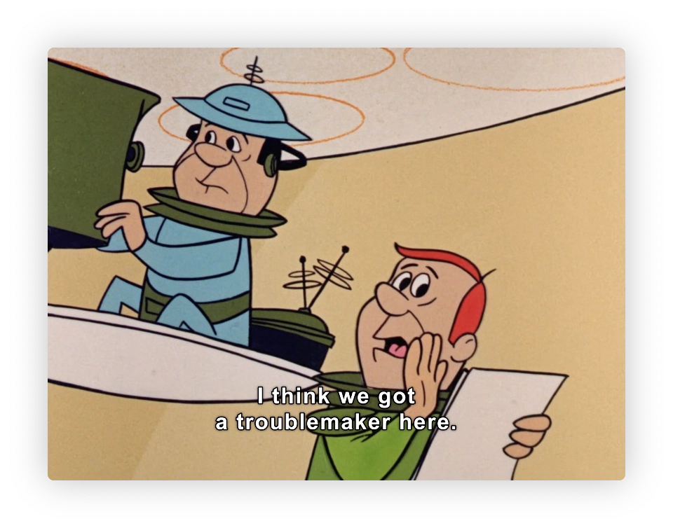 Two cartoon characters from the classic animated television series "The Jetsons." The character on the left, wearing a green and blue outfit with a hat, is seen piloting a large floating TV camera platform. The character on the right, speaking and holding a piece of paper, is a TV Host. The text caption in the image says, "I think we got a troublemaker here," reacting to a situation involving George Jetson. The overall setting and style are indicative of the mid-20th century American animation, with a focus on a humorous portrayal of future daily life and technology.