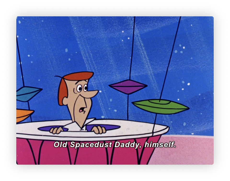 This image looks like a scene from an animated series featuring a character resembling the style of classic Hanna-Barbera cartoons. The character, a man with brown hair and a white shirt, appears to be sitting at a table looking at colorful, flying saucer-like objects suspended in the air. The setting seems to be a stylized, whimsical interior, possibly representing a space or futuristic theme, indicated by the starry backdrop outside of a window. The caption on the image reads "Old Spacedust Daddy, himself," suggesting a humorous or playful element related to the character or the scene.