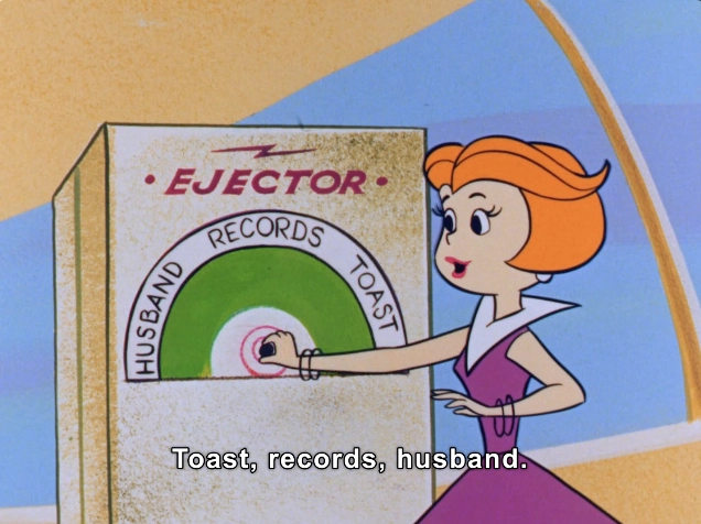 In this vibrant scene from a retro animated series, a stylish character with short, orange hair and a sophisticated purple dress interacts with a whimsical machine labeled "EJECTOR." The machine presents three options: "TOAST", "RECORDS," and "HUSBAND,"  indicated by colorful circular dials. 

The character appears engaged, poised to make a choice, evoking a playful yet futuristic domestic setting. The overall aesthetic combines humor and nostalgia, characteristic of mid-20th century animation. This image captures a lighthearted moment that reflects societal themes of the era, particularly in domestic technology and gender roles.