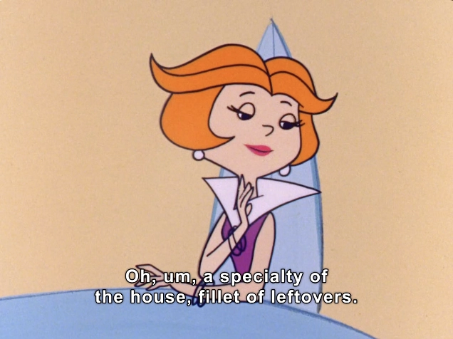 The image features a scene from a classic animated show, showcasing a character with distinctive orange hair styled in a bob cut. She is depicted with a thoughtful expression, sitting at a sleek, modern table. The background has a minimalist design, enhancing the character's elegant appearance. 

The character, dressed in a purple outfit with a dramatic collar, is engaged in a light-hearted conversation, as indicated by the text displayed at the bottom of the image. The dialogue humorously mentions a dish referred to as "fillet of leftovers," suggesting a playful and witty tone. 

This visual captures the essence of vintage animation, characterized by its vibrant colors and charming character design, appealing to fans of retro cartoons.